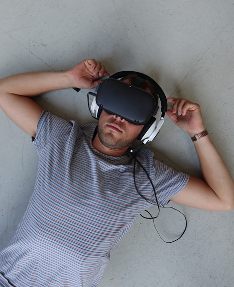 Ein Mann mit einer Virtual Reality Brille liegt auf dem Boden.