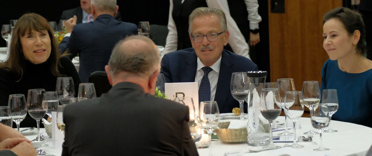 Menschen sitzen an einem runden Tisch und unterhalten sich