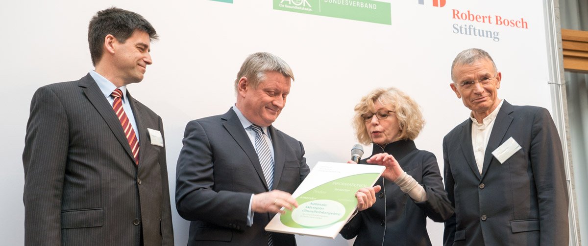 Handover of the document with four people in the picture