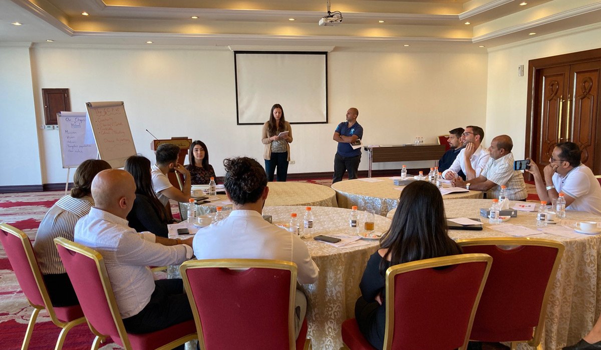 Participants of the workshop listen to a presentation in a seated position