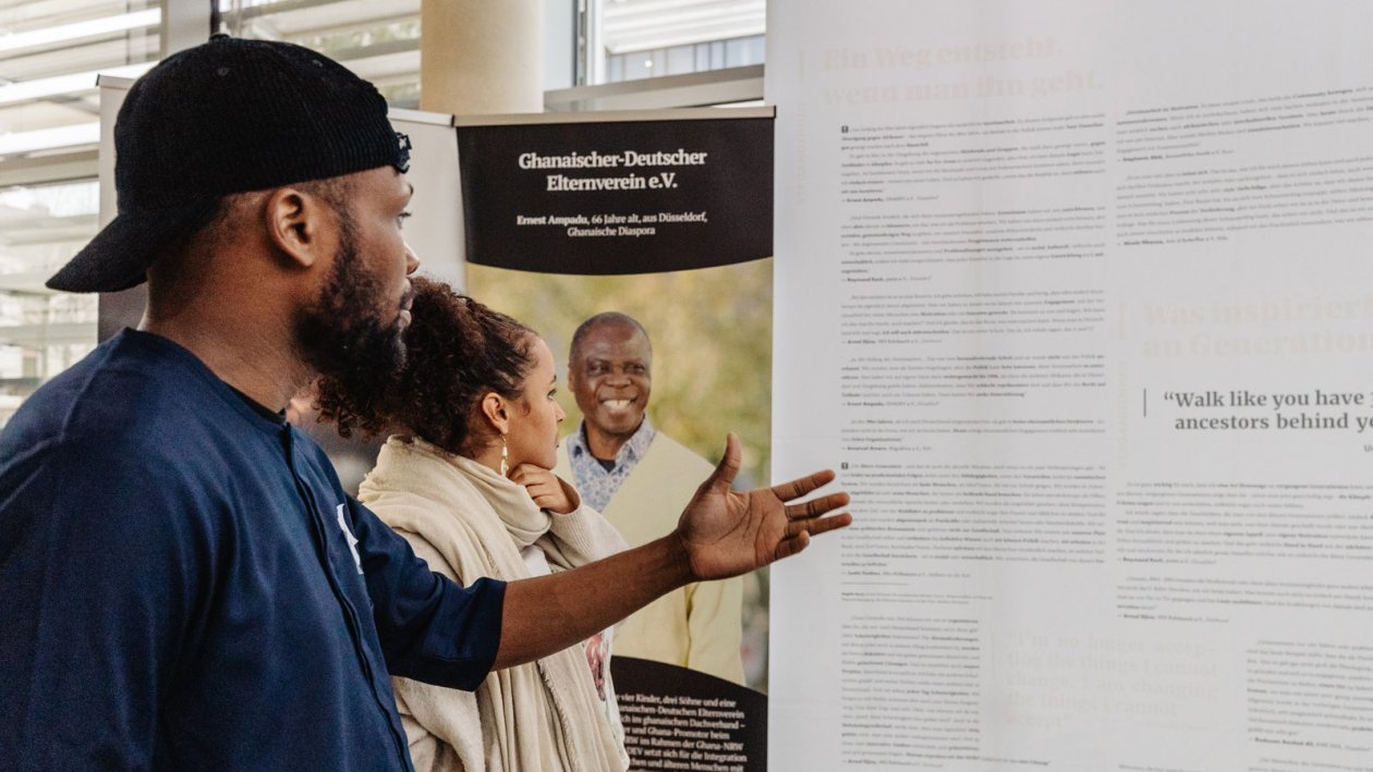 Two participants read a poster board