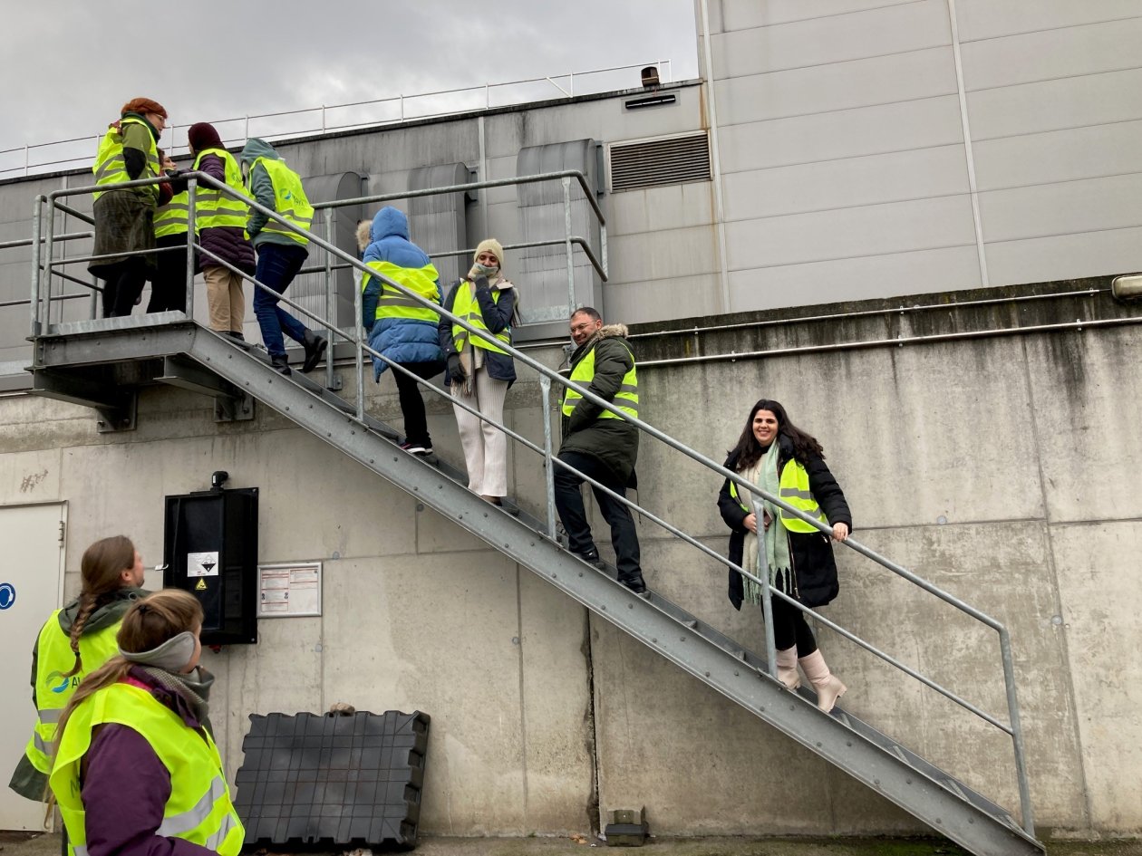 Gruppe in Sicherheitskleidung auf einer Fabriktreppe