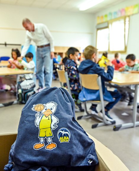 Grundschulklasse, im Vordergrund liegt ein Turnbeutel von ALBA BERLIN