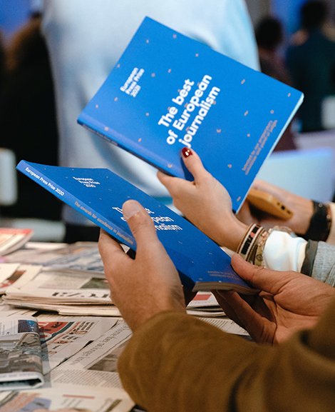 Frauenhände halten blaue Broschüren mit der Aufschrift "The best of European Journalism"