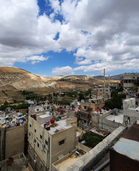 Eine Skyline der Stadt Al-Mansoura bei Damascus, zu sehen ist eine Mischung aus Ruinen, Baustellen und einige Fabrikschornsteine