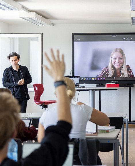 Berufsschüler:innen in einem Klassenzimmer mit Videokonferenz