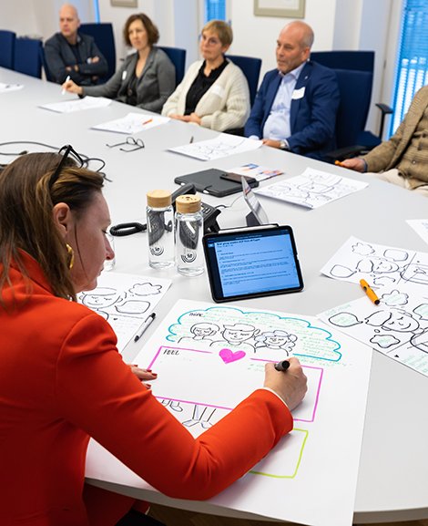 A workshop participant in Eupen writes a poster.