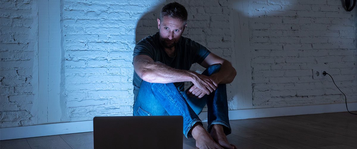 Man looking thoughtfully at his laptop