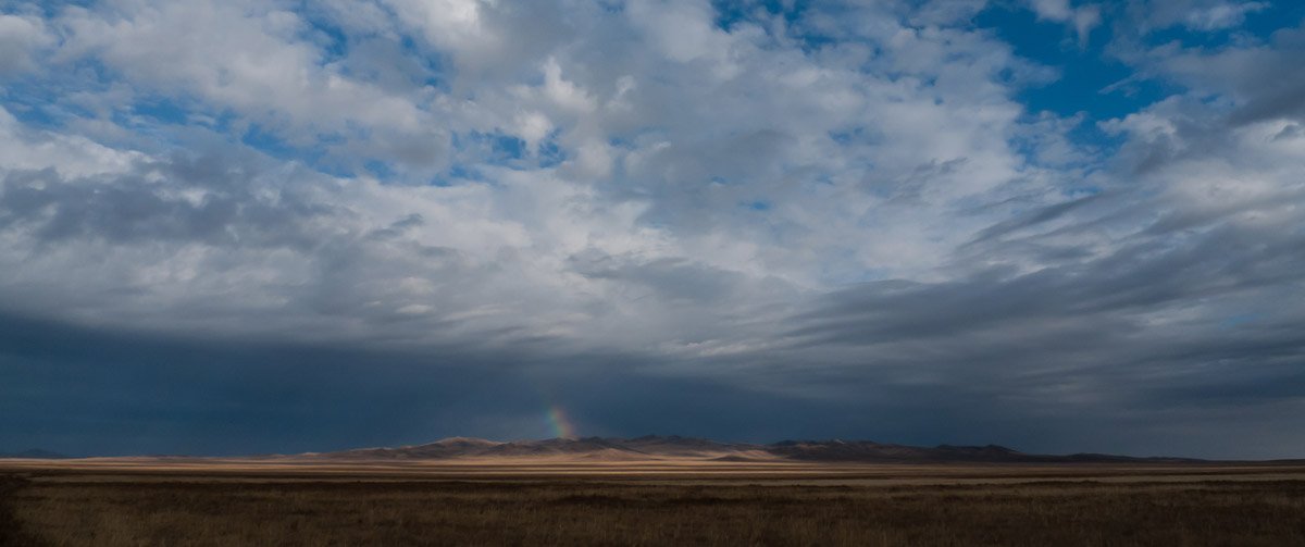 Himmel über der Steppe mit Regenbogen