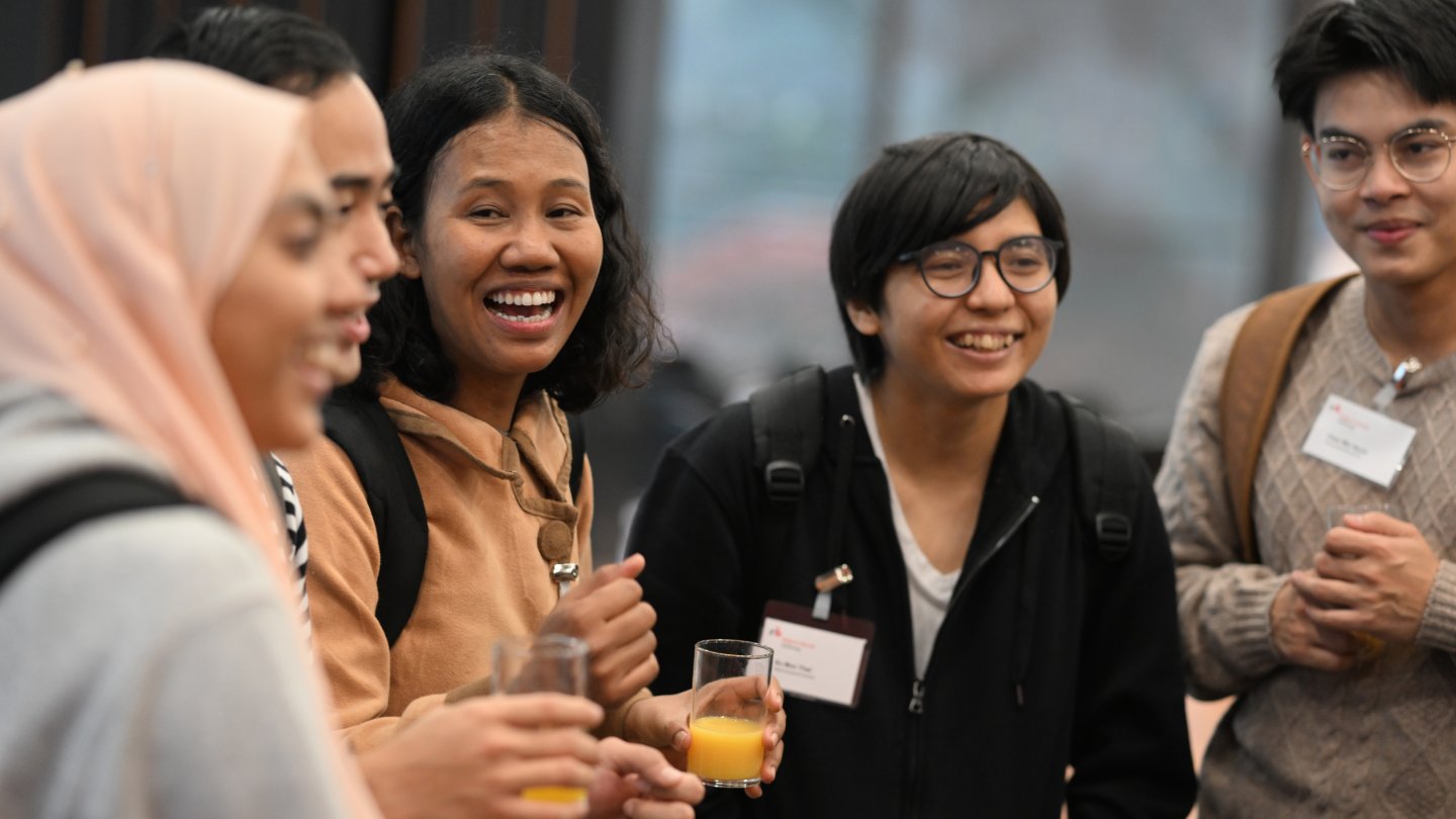 Group of young people standing in a semicircle and laughing