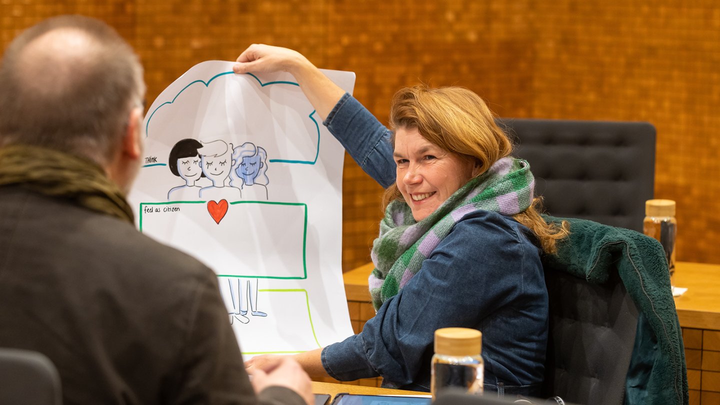 A woman shows a workshop poster to a man.