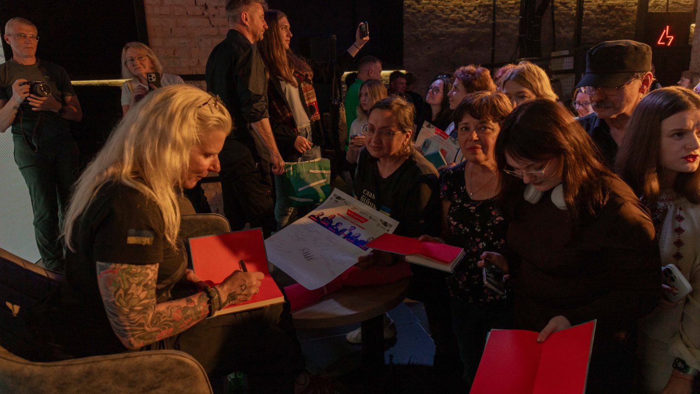 Eine Autorin signiert ihr Buch beim Literaturfestival Meridian in Saporischschja