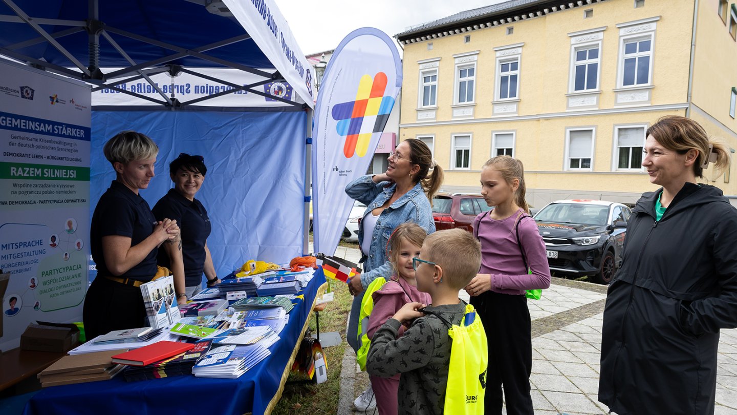Bürger:innen vor dem Infostand von Common Ground