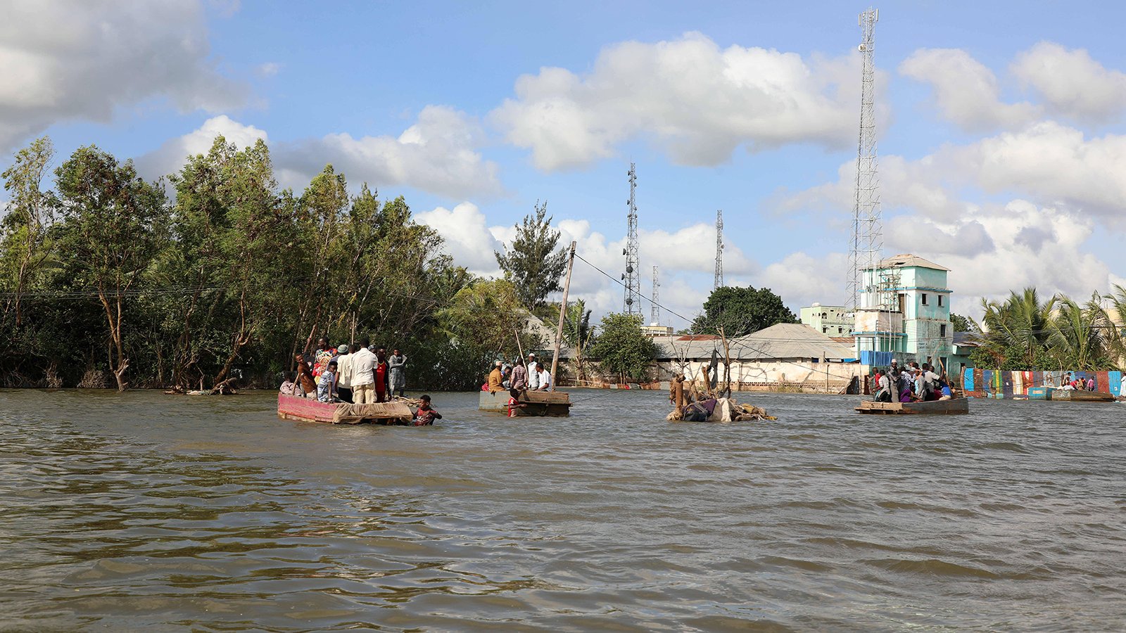 Menschen rudern auf einer überfluteten Straße in Afgoye, Somalia, Aug. 9, 2020.