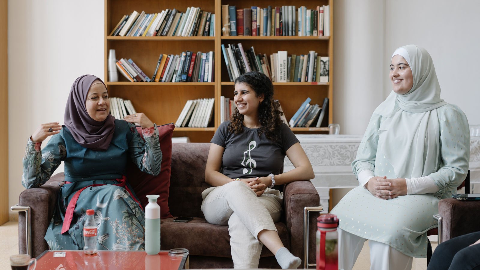 Drei Frauen sitzen auf einem Sofa und diskutieren