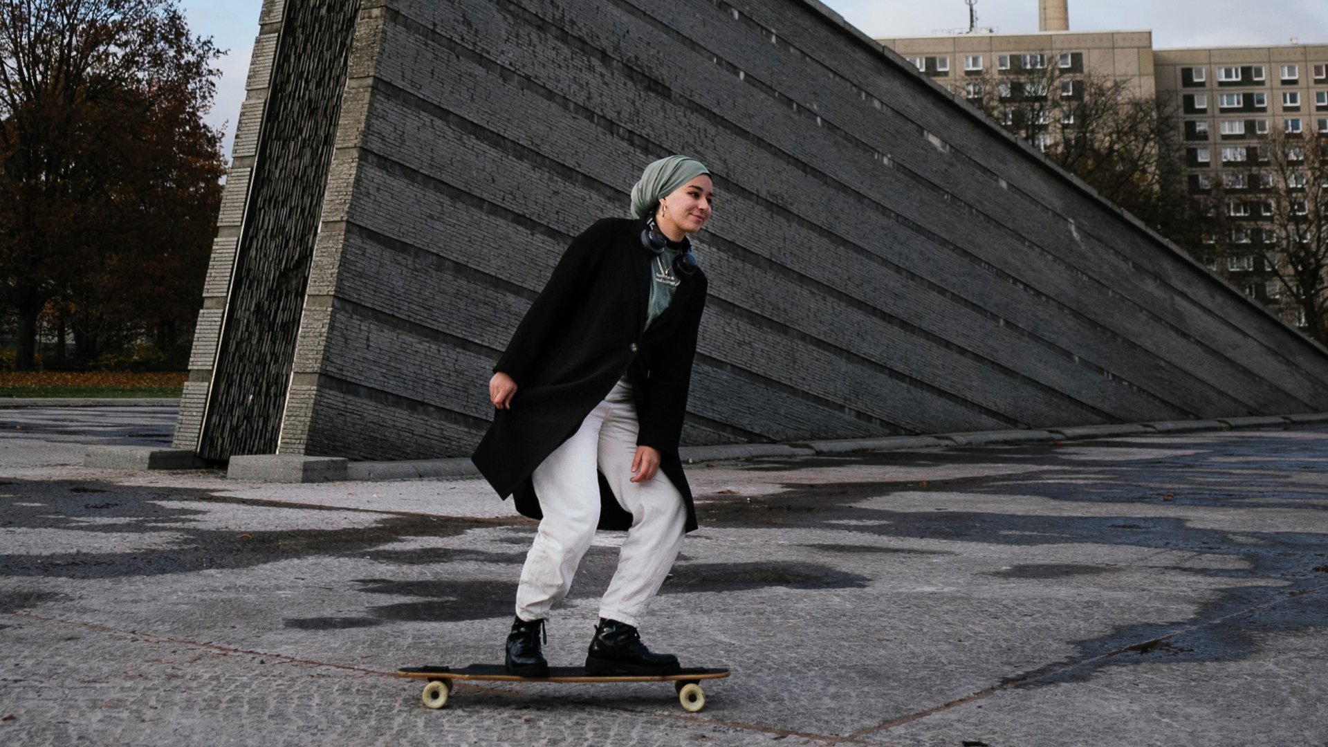 Eine Frau mit Kopftuch fährt Skateboard