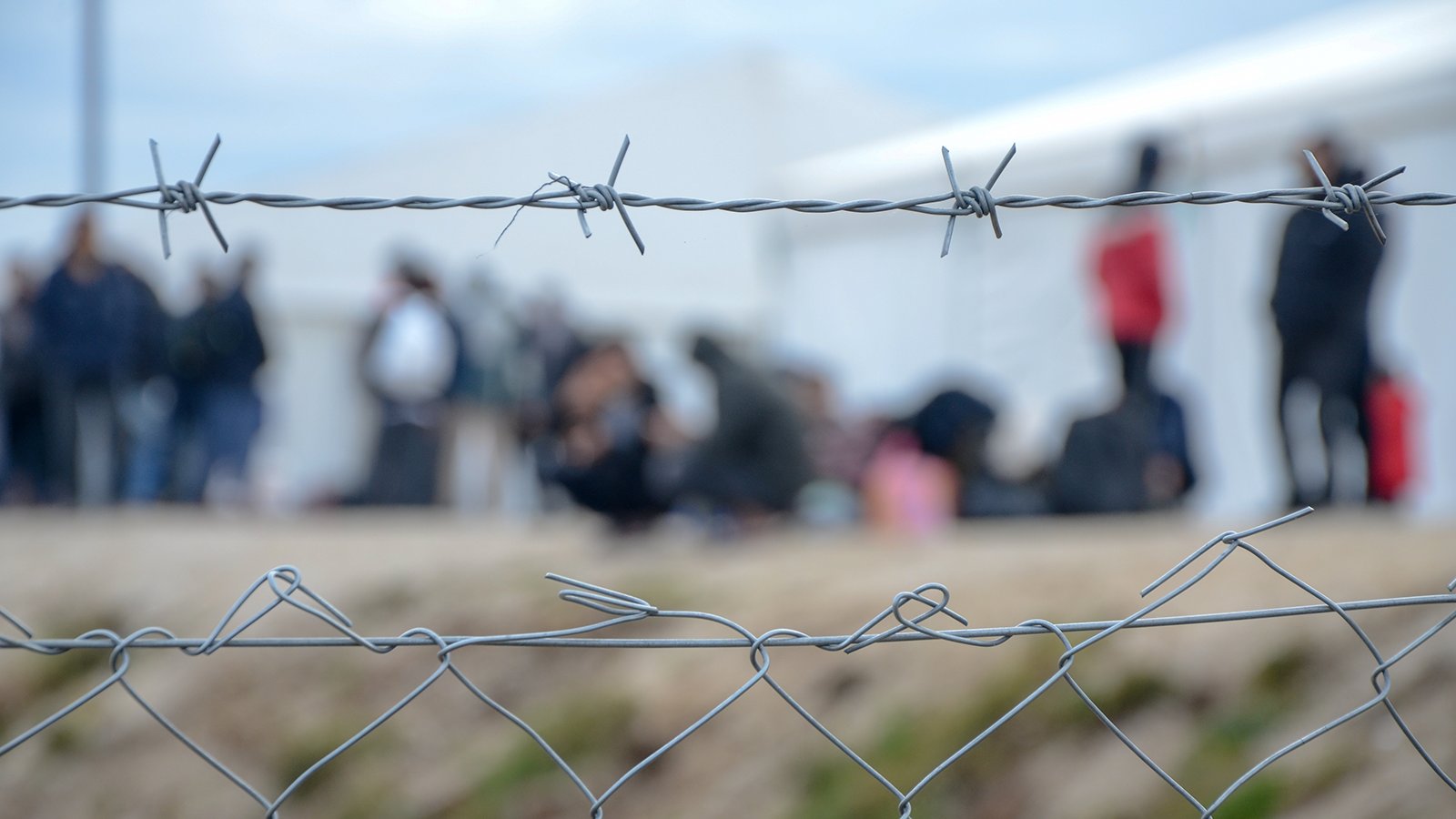Wire mesh fence in front of refugee camp
