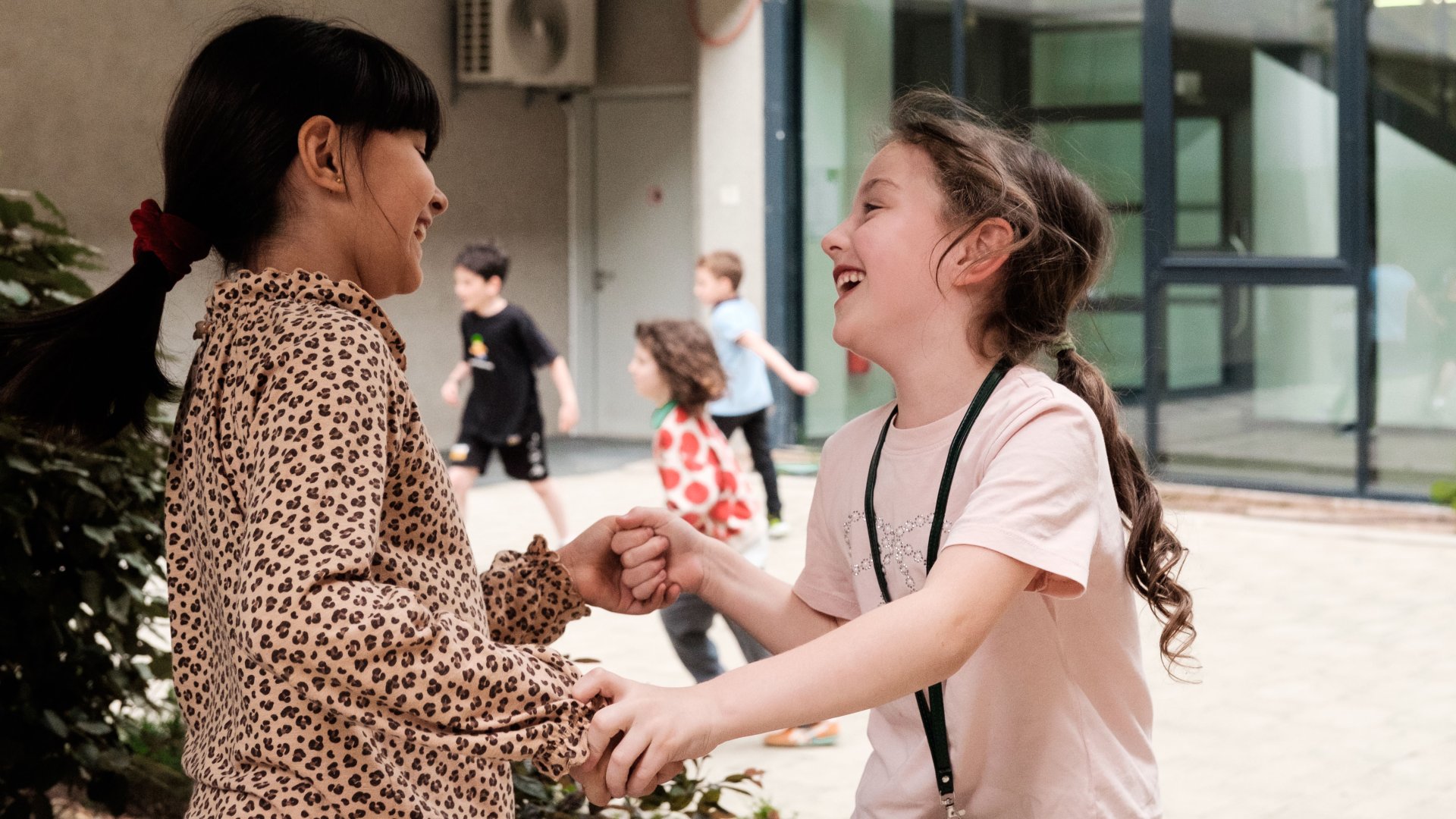 Zwei Mädchen an der Deutschen Internationalen Schule in Tiflis halten sich an den Händen und lachen