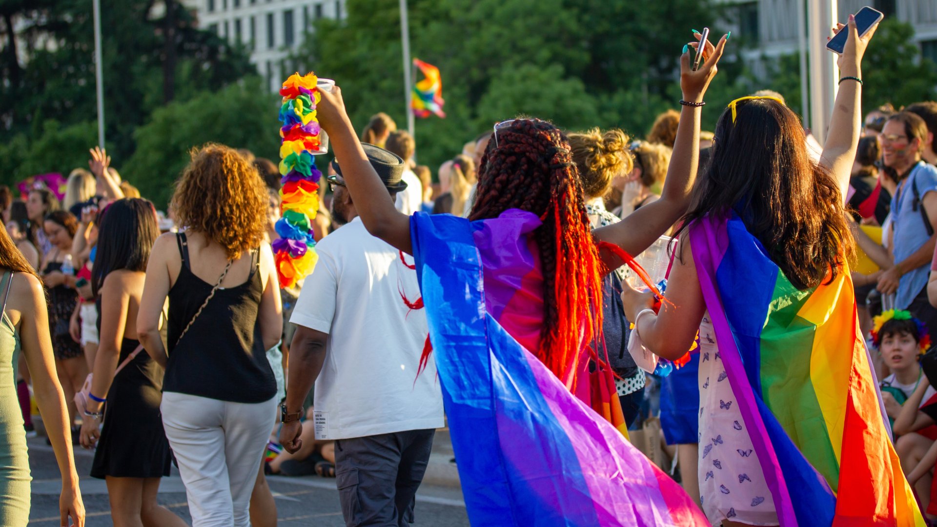 Eine Gruppe von Frauen zieht mit Regenbogenfahnen durch die Straßen