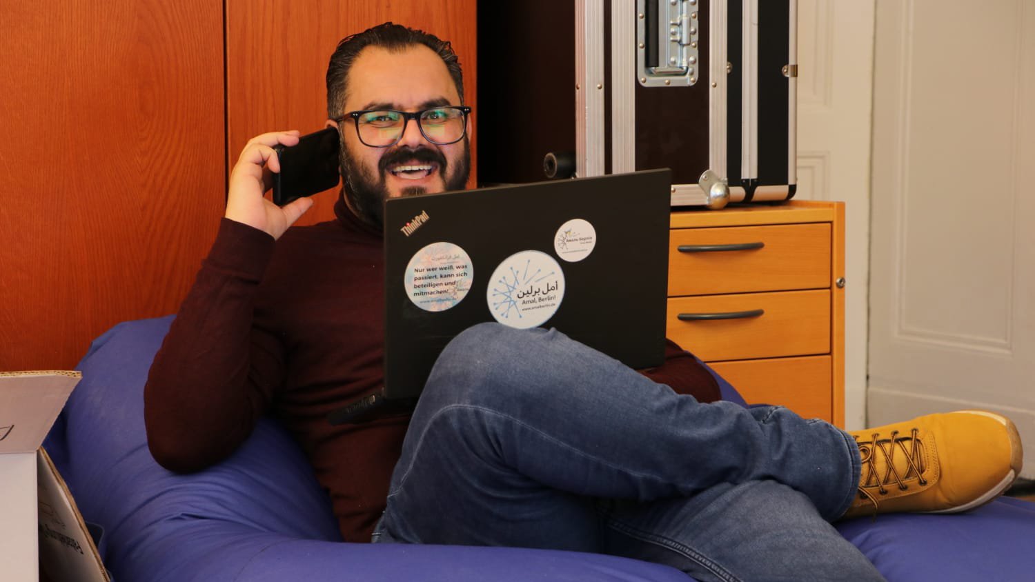 Der Journalist Khalid Al Aboud sitzt auf einem Sessel und telefoniert