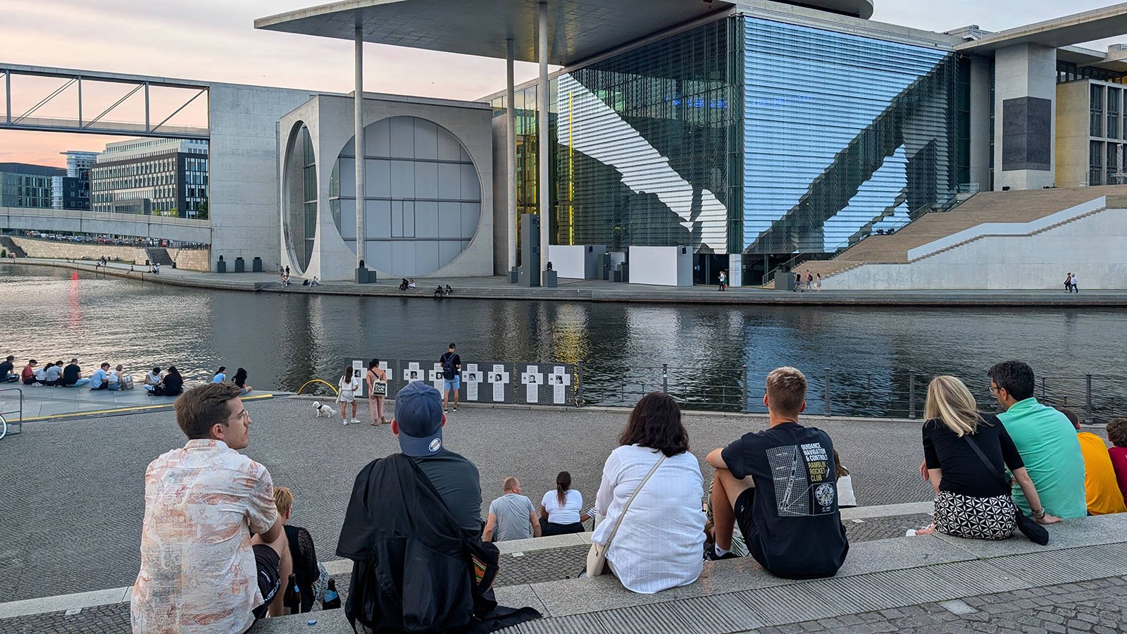Bürger:innen sitzen auf einer Treppe im Berliner Regierungsviertel