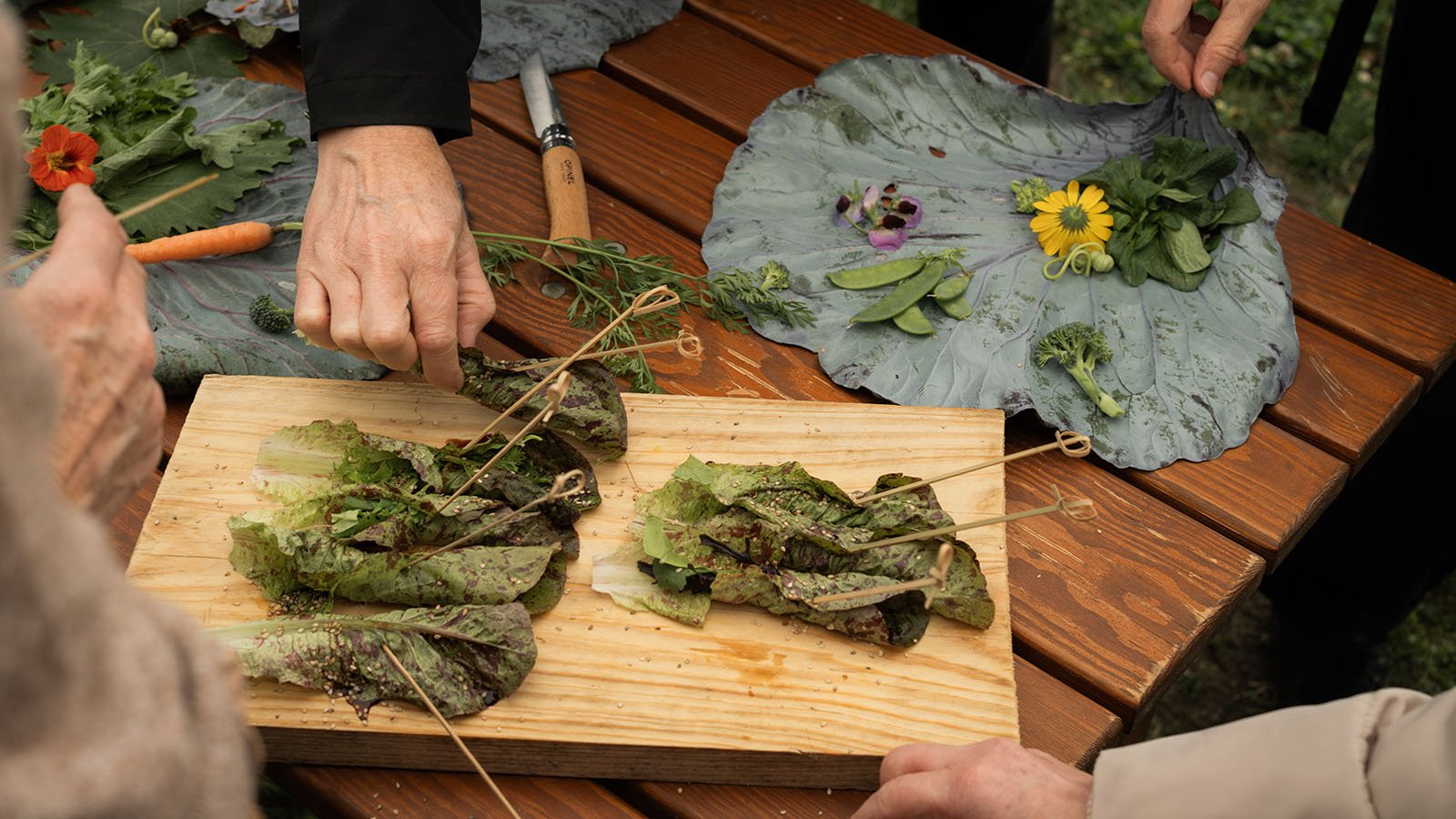 Participants of “Zukunft aufgetischt!” arranging salad and edible flowers.