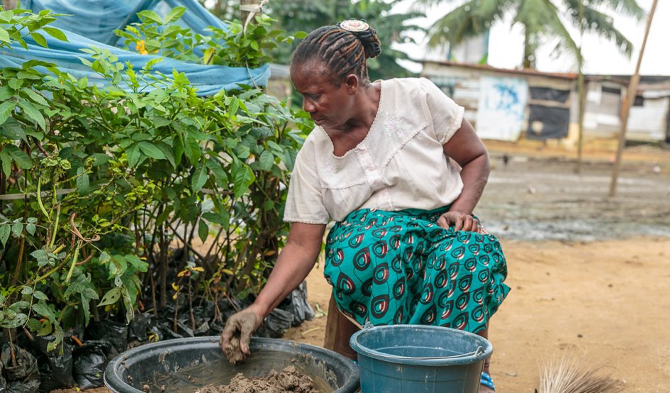 Woman in front of a planter with soil